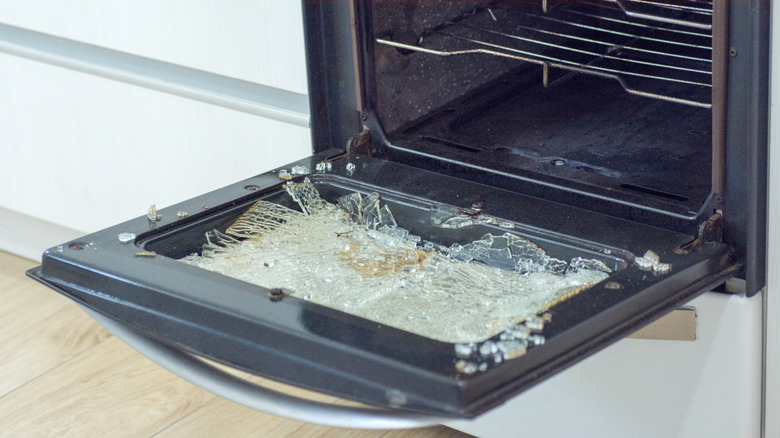 Open oven door with shattered grass