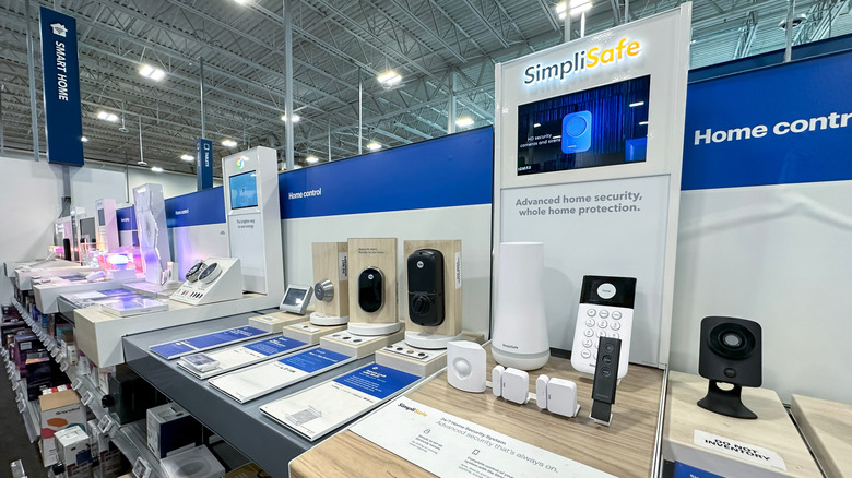 SimpliSafe home security products sit on a shelf in the smart home section of a store.