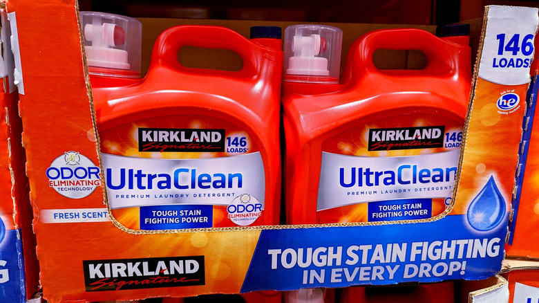 Jugs of Kirkland Signature UltraClean laundry detergent in boxes on store shelf