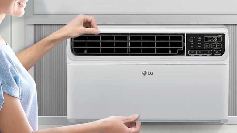Woman adjusting LG window air conditioner