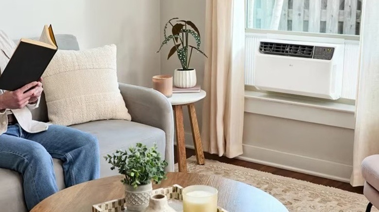 Person sitting in small room with window AC