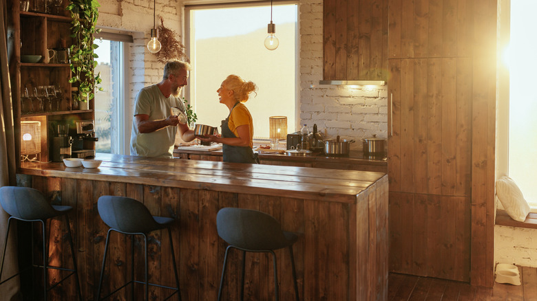 Older couple working together in a beautiful kitchen setting