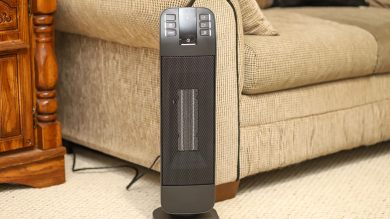 Black space heater sitting on living room floor in front of couch