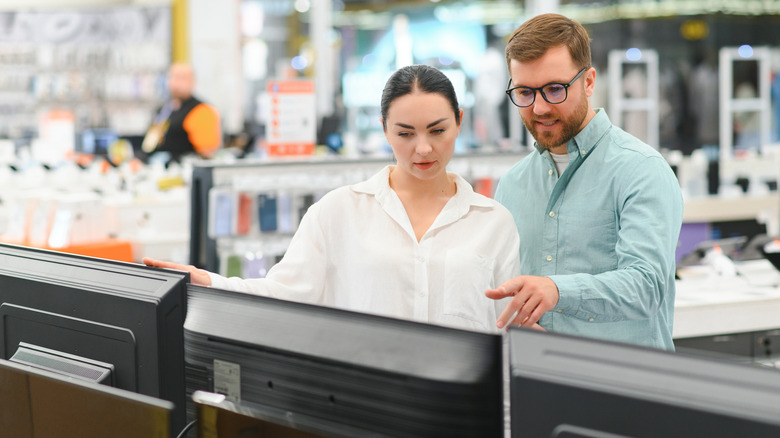 Couple browsing TVs in a store