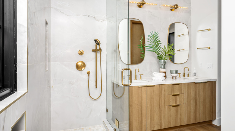 Gold shower head and fixtures in bathroom