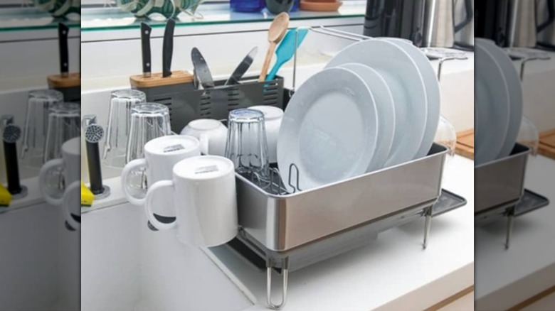 The simplehuman dishrack with knife block, loaded with drying dishes on a kitchen counter.