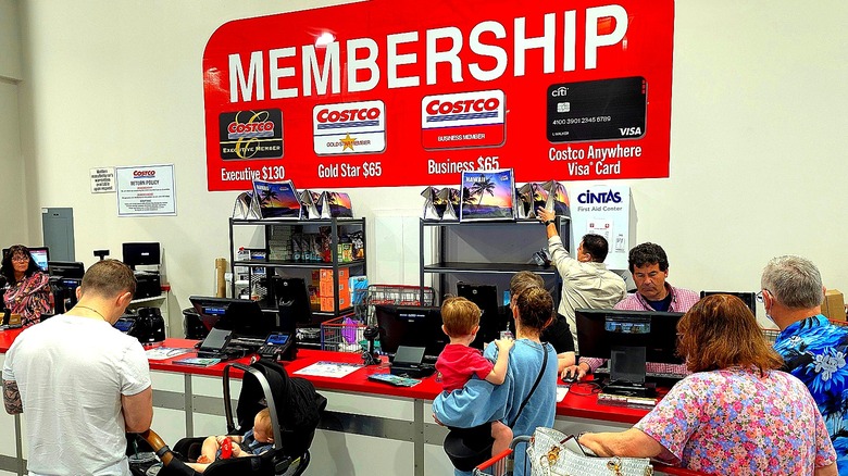 Shoppers inside a Costco at the customer service station where membership sign-up takes place