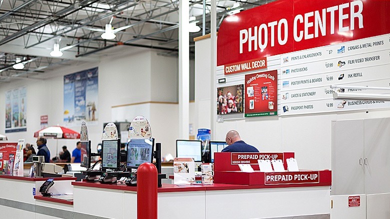 A Costco photo center with a man working on a computer