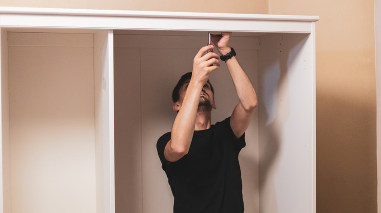 Man building a closet organizing system