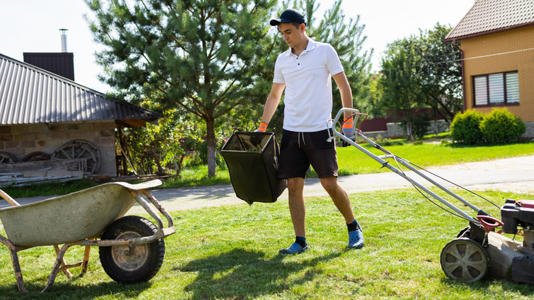 A man picking up items in a yard