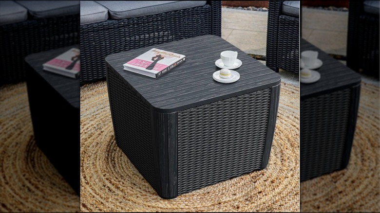 Keter Luzon Outdoor Storage Table from Costco in a patio setting with items on top of it