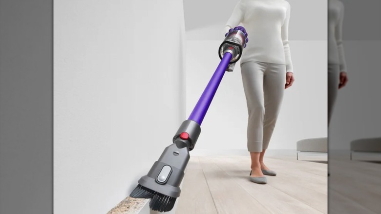 Dyson vacuum cleaner cleaning baseboards in a home