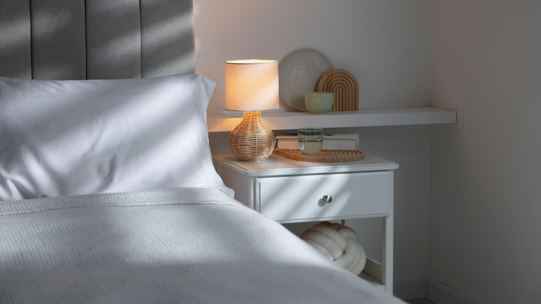 white nightstand next to bed with white bedding