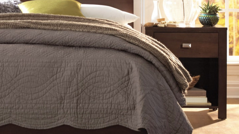 Paxton nightstand next to a bed with a gray comforter