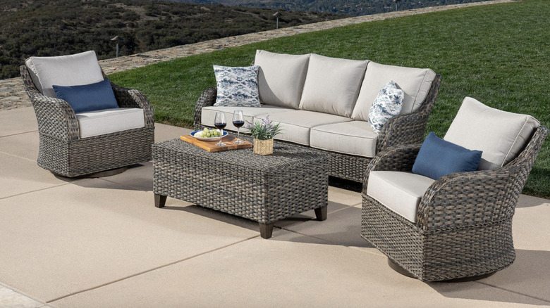 A gray wicker outdoor furniture set with blue accents