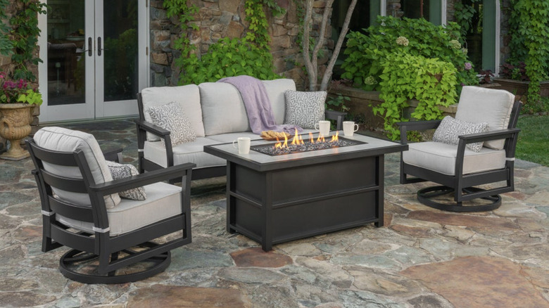 A four-piece patio set with two chairs, a sofa, and a fire pit table
