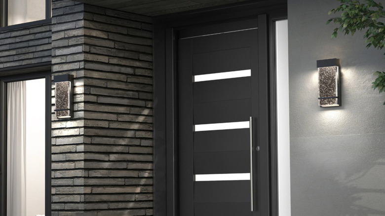 The front door of a modern house flanked by Artika's Skyler Bubble Glass Sconce lights