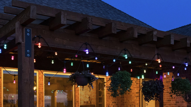 Enbrighten's Vibe Wi-Fi Color Changing Vintage String Lights hung from a pergola