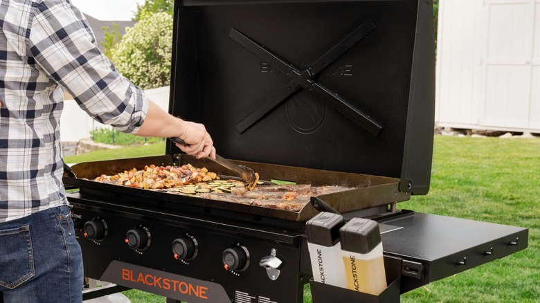 A man cooking on a Blackstone griddle