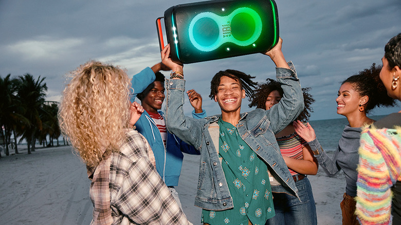 A JBL PartyBox speaker at a beach party