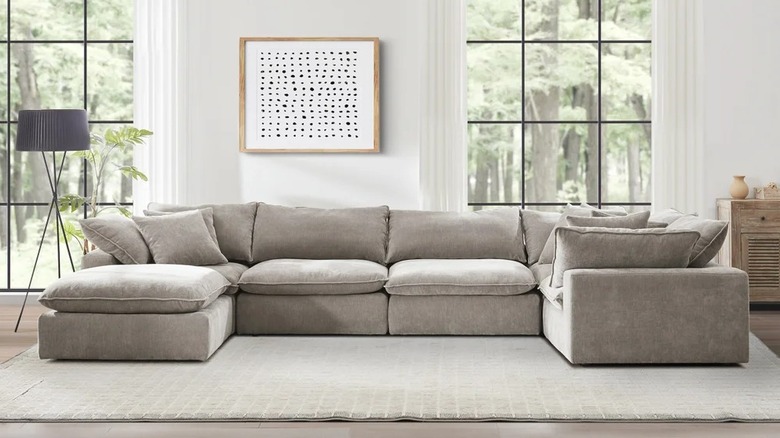 A large beige sofa in a living room with neutral decor