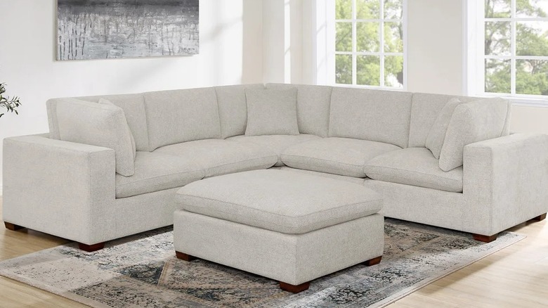 A light gray modular couch with ottoman in a living room