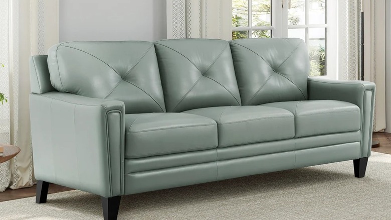 A bluish-green leather sofa in a living room
