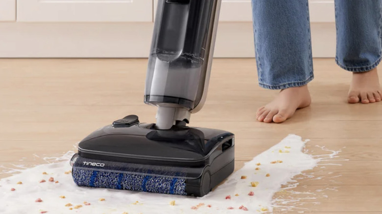 Someone using a Tineco combo mop and vacuum to clean a big mess