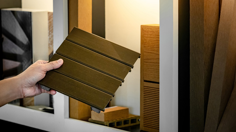 A person holding a wood-look tile sample