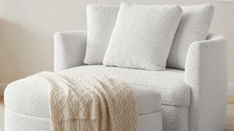 Holley Oversized Fabric Accent Chair with tan throw pillow draped on it