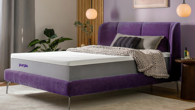 The PurpleRenew 11" Gel Grid Mattress on a purple bed frame in a bedroom