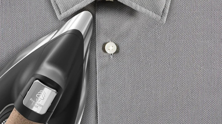 A closeup of the steam station ironing a grey shirt