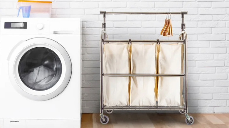 A laundry cart sitting near a dryer