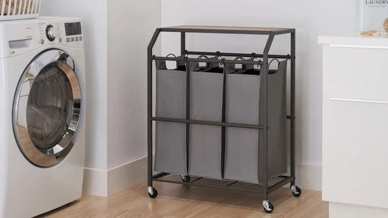 A rolling cart in a laundry room near a washing machine