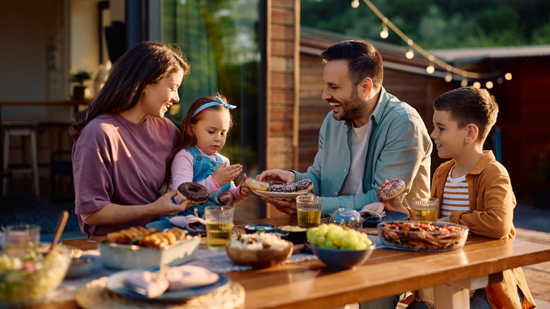 family of four having a meal at picnic table