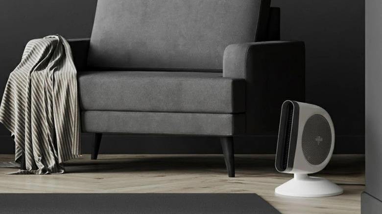 The Vornado Strata 8C Omni Fan on the floor in front of a gray armchair
