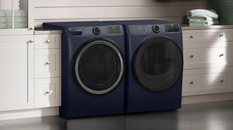 Sapphire blue GE washer and dryer side by side next to drawers and cabinets