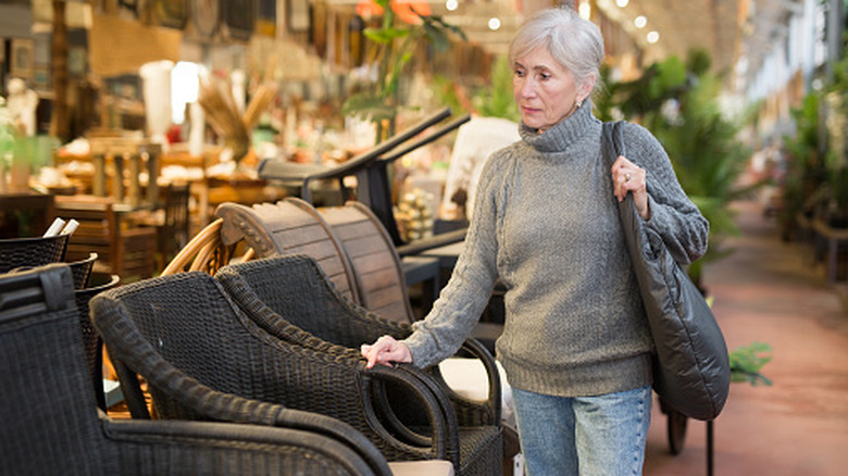 A senior woman shops for outdoor furniture.
