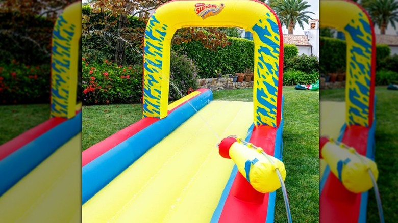 An inflated slip n' slide set up on a lawn in a yard