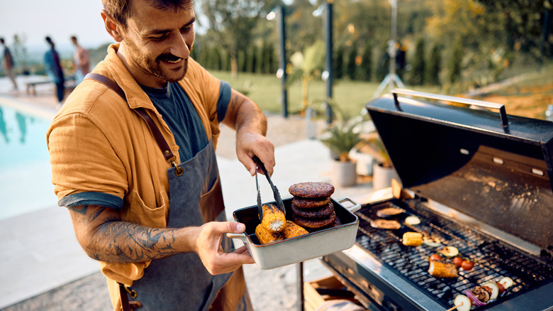 A man serving up grilled meats and other foods