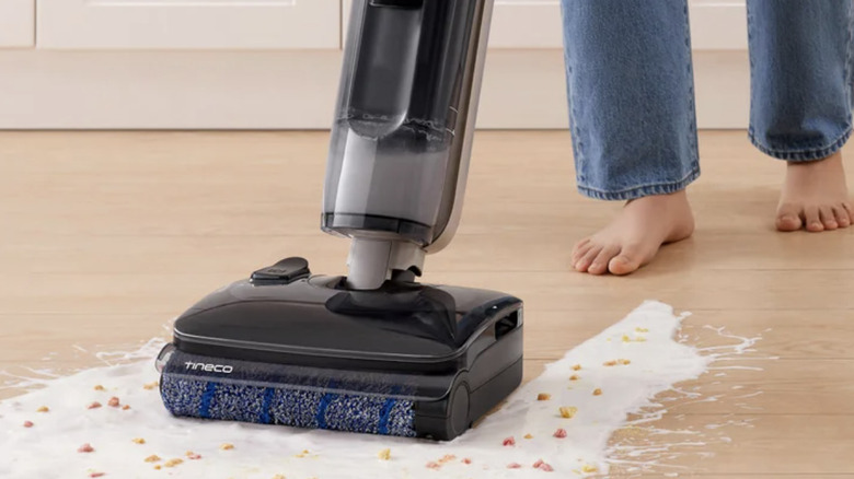 Someone using a Tineco combo mop and vacuum to clean a big mess