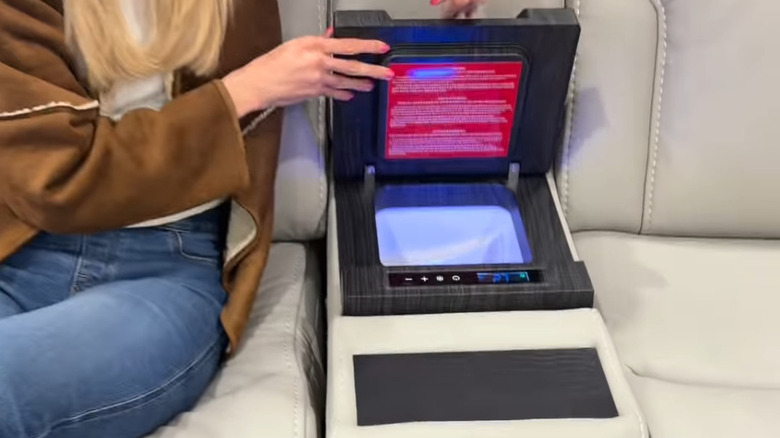 A woman's hands show the refrigerator inside the new Costco couch.