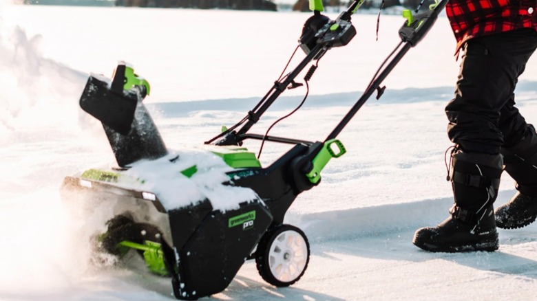 Man pushing the Greenworks snow thrower through the snow