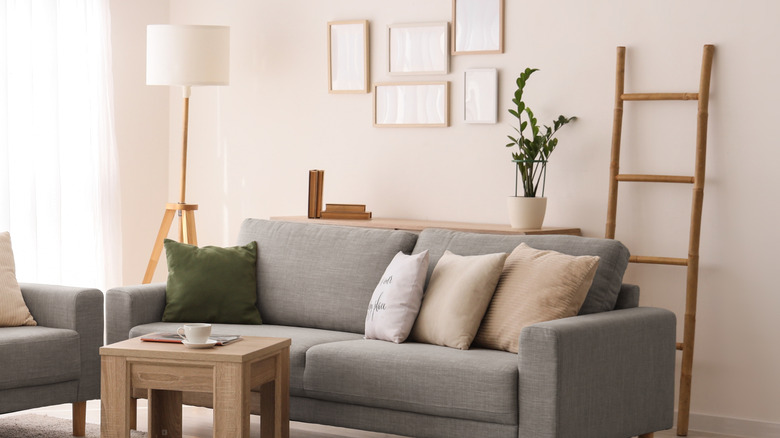 Neutral living room with gray loveseats and wooden sofa table and side table