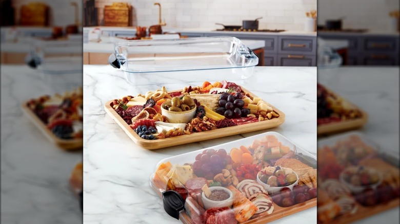 Two appetizer boards on counter, one with lid on and other open