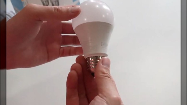 person holding smart lightbulb
