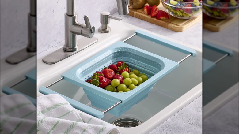 Expandable colander over sink with washed fruit