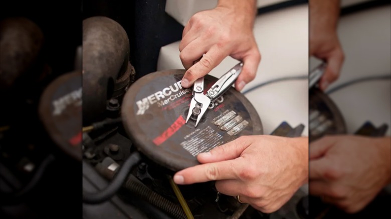 person using multitool to adjust bolt