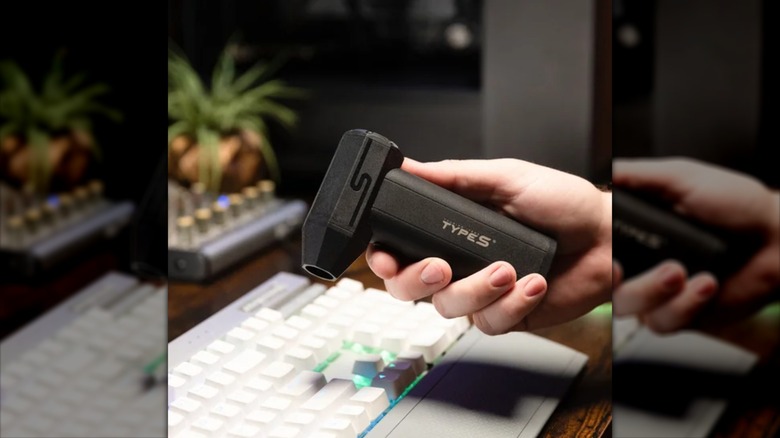 Person using electric duster on keyboard