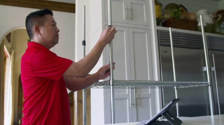 Man assembling a TRINITY garage shelf